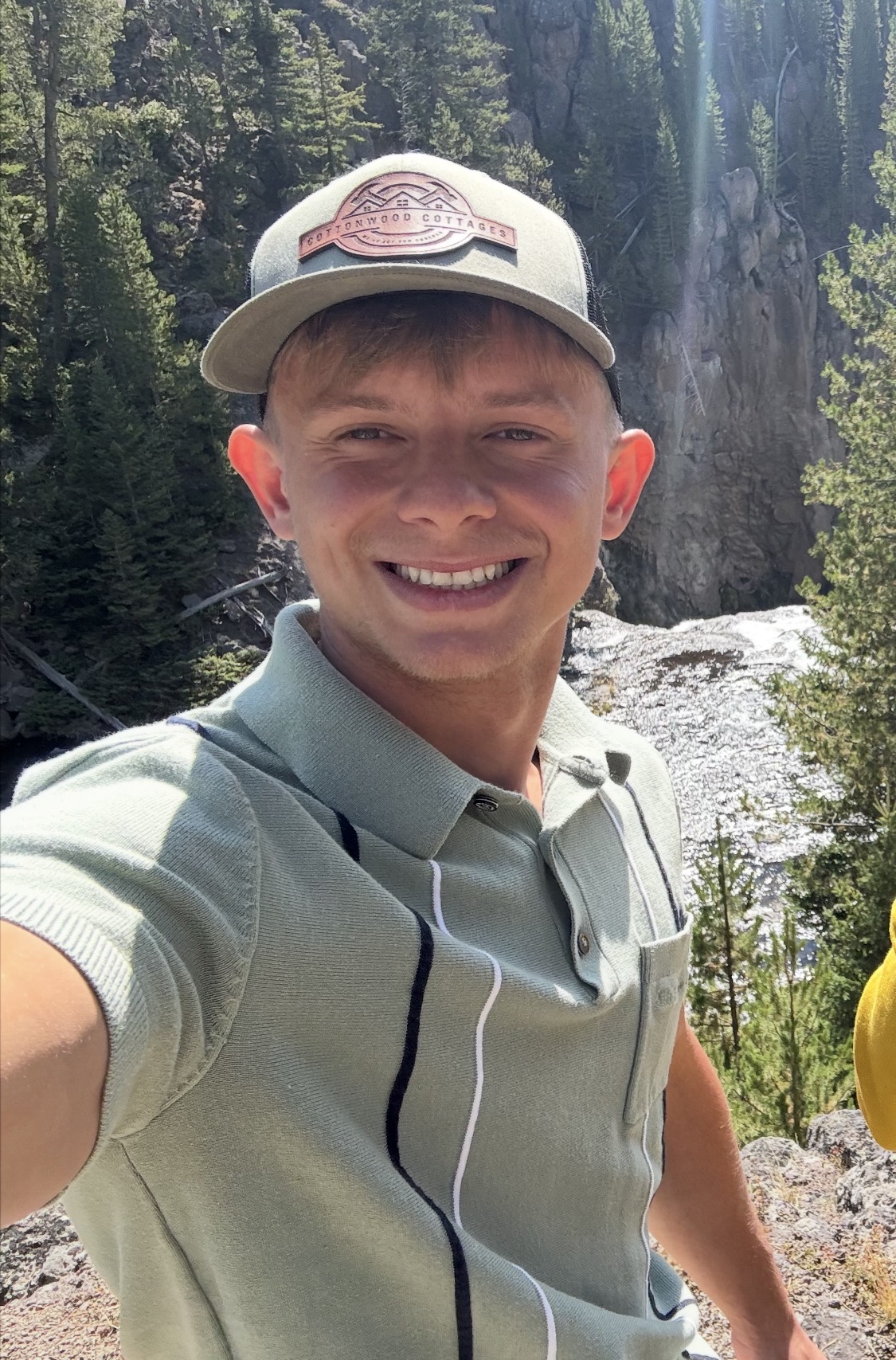 Alex, your local portable building specialist, smiling outdoors in an olive polo and Cottonwood Cottages cap